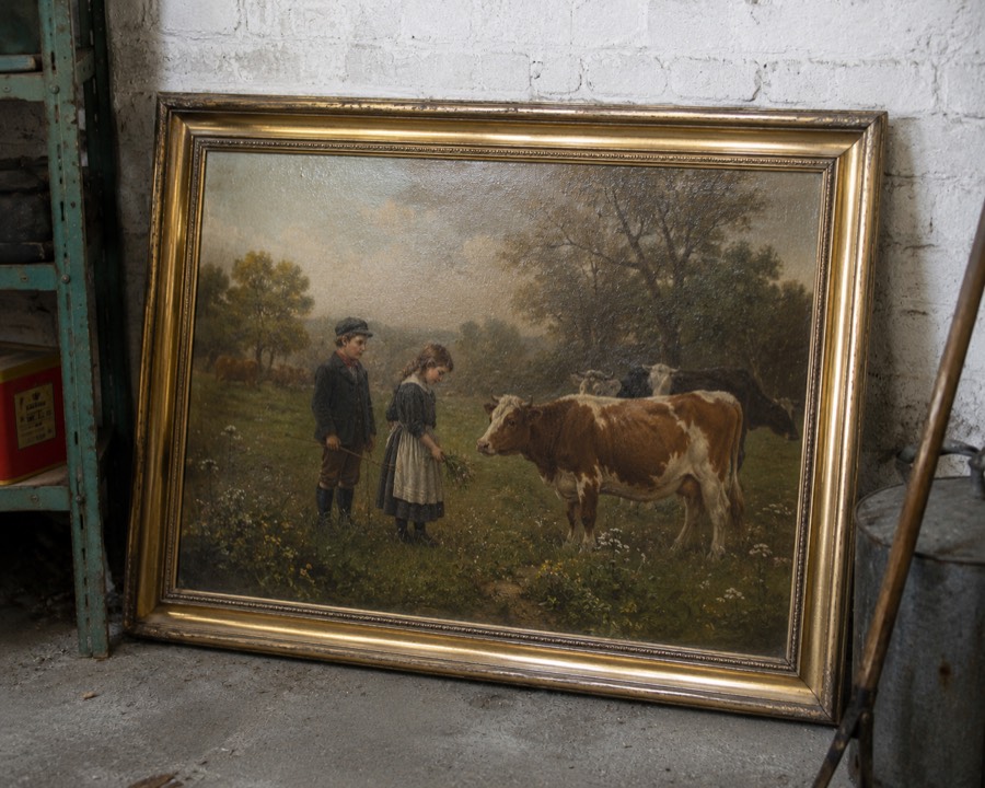 A gilt-framed oil painting propped against a garage wall